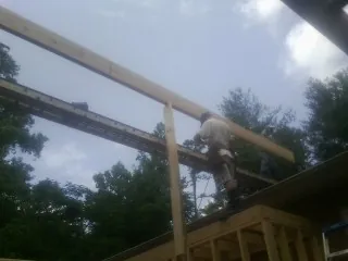 Carpenter setting a ridge beam over a new addition frame — Ice Dam Removal by Roofing Brothers in Fort Ogden